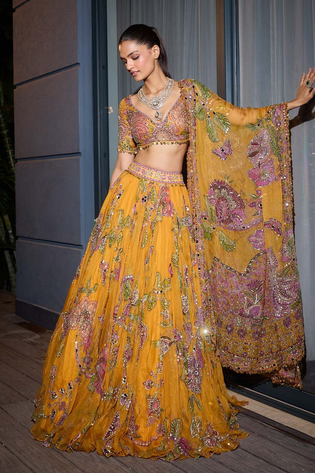 Mustard yellow floral lehenga with an embellished blouse and matching sheer dupatta.